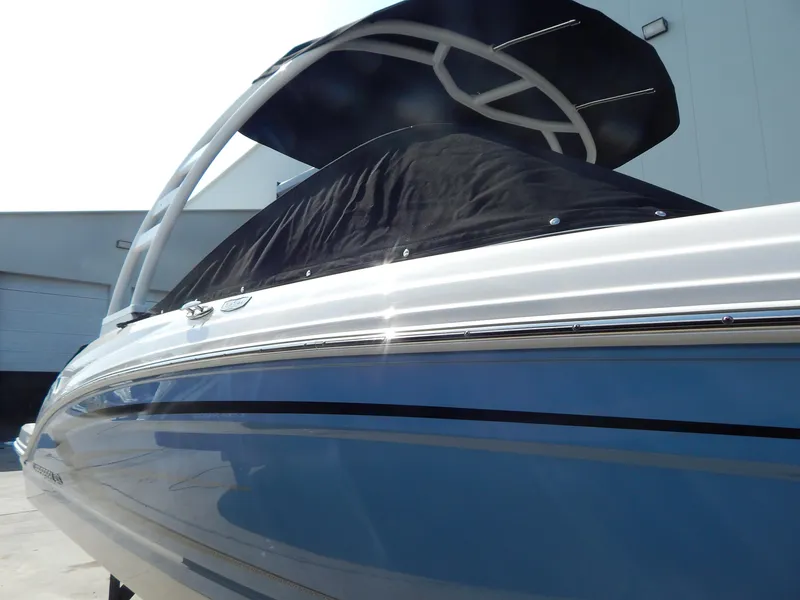 Slide: The Image of 2022 Chaparral 23 SSi OB boat with sleek blue hull and modern design. - 23