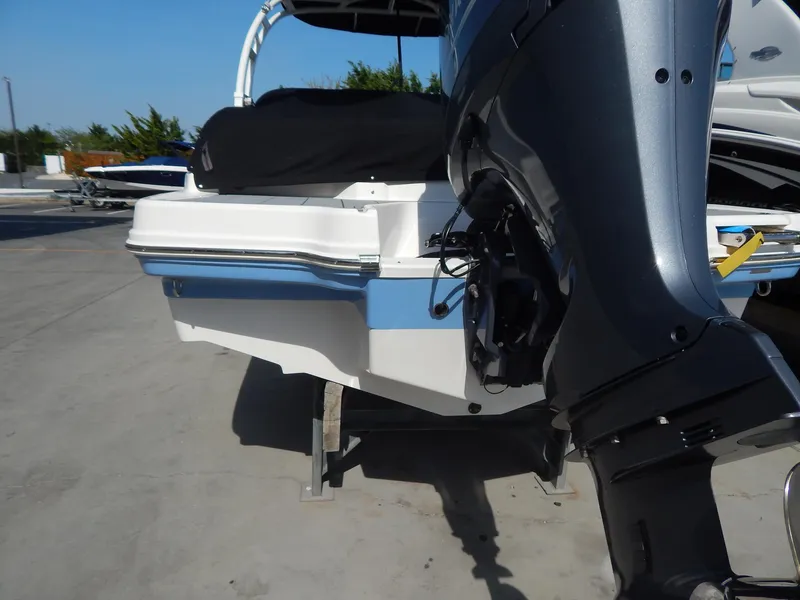 Slide: The Image of 2022 Chaparral 23 SSi OB boat with outboard motor, docked on a sunny day. - 27
