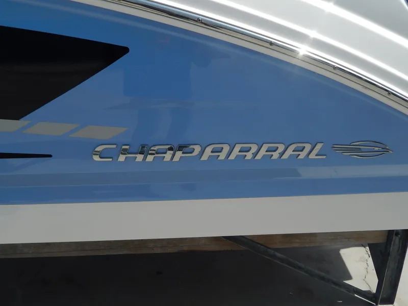 Slide: The Image of 2022 Chaparral 23 SSi OB boat side view with logo and blue detailing. - 3
