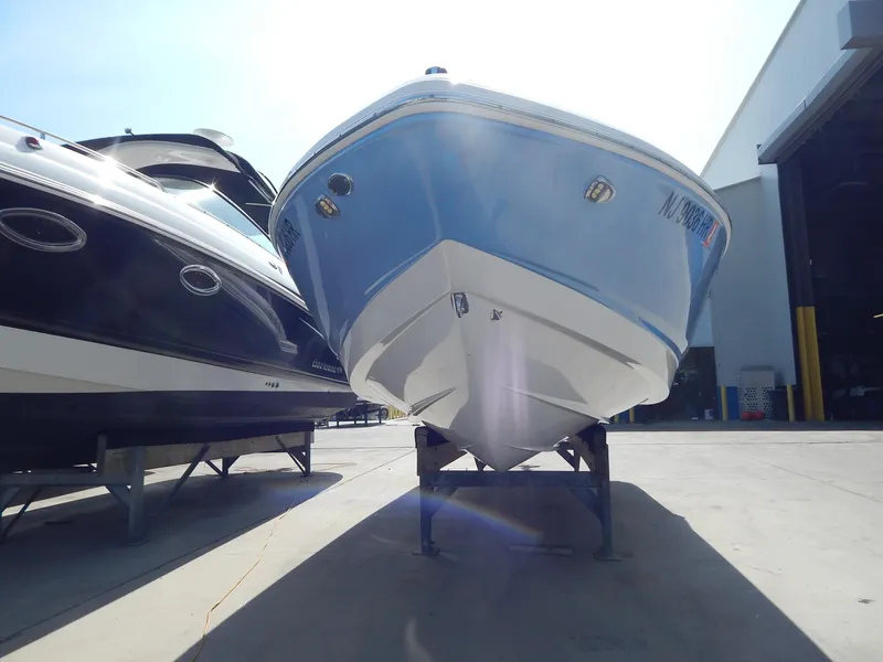 Slide: The Image of 2022 Chaparral 23 SSi OB boat in a marina, front view, blue and white hull. - 30