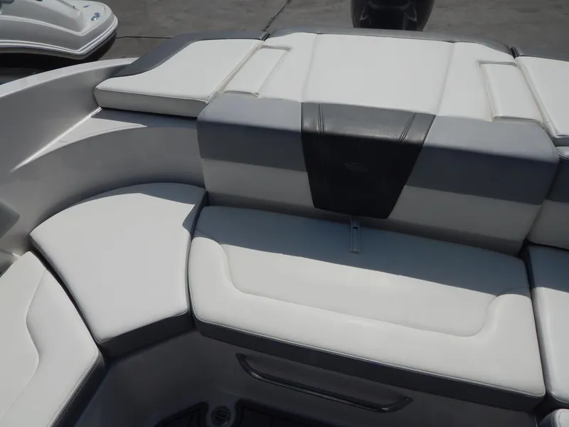 Slide: The Image of 2022 Chaparral 23 SSi OB boat interior seating, featuring sleek white and gray upholstery. - 45
