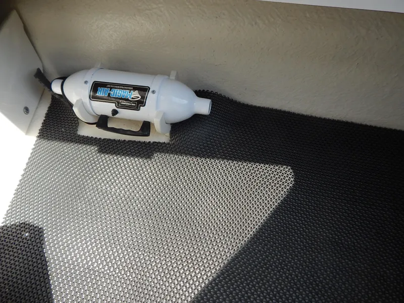 Slide: The Image of 2022 Chaparral 23 SSi OB boat interior with mounted fire extinguisher on textured flooring. - 48