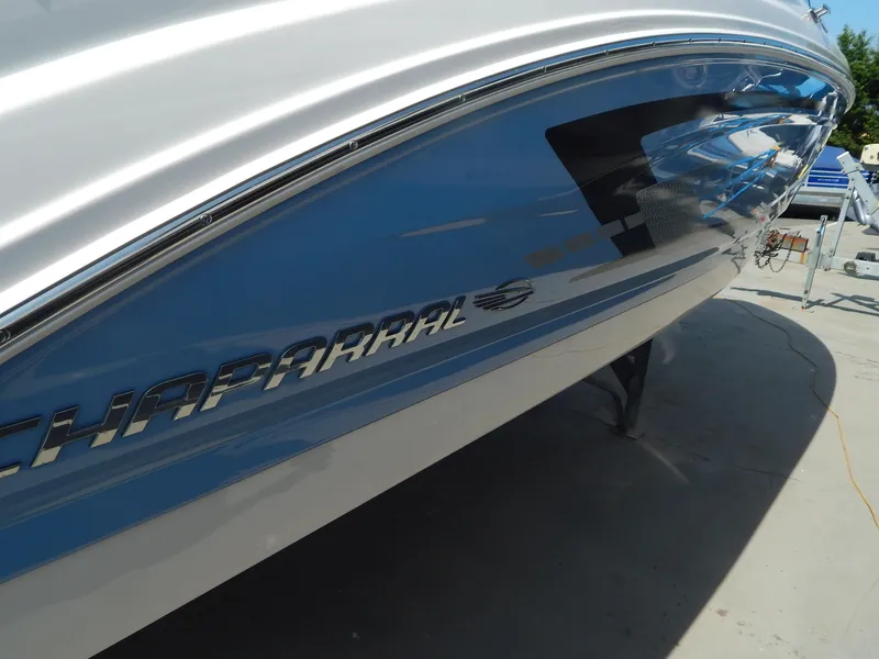 Slide: The Image of 2022 Chaparral 23 SSi OB boat, sleek blue and white hull design. - 7