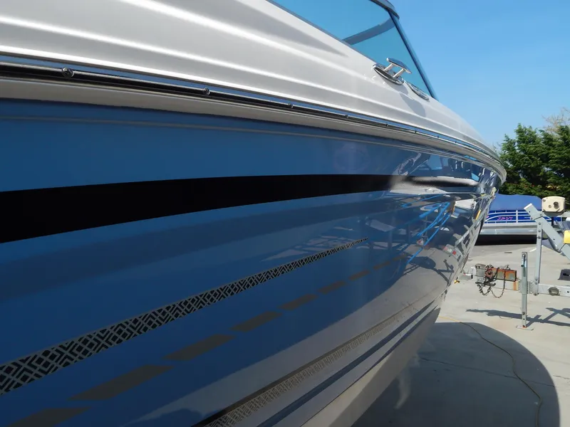 Slide: The Image of 2022 Chaparral 23 SSi OB boat, sleek blue and white exterior, docked outdoors. - 8