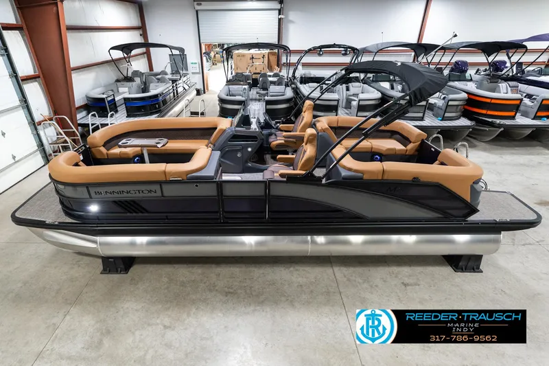 Slide: The Image of 2025 Bennington 24 MSB pontoon boat with tan seating in a showroom. - 1
