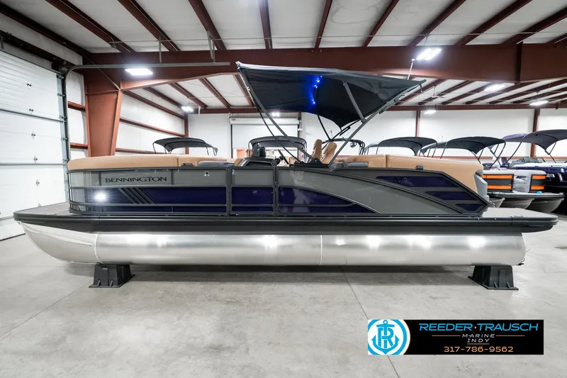 Slide: The Image of 2025 Bennington 24 MSB pontoon boat in showroom with canopy and sleek design. - 11