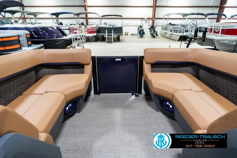 Slide: The Image of 2025 Bennington 24 MSB pontoon boat interior with tan seating in a showroom. - 18