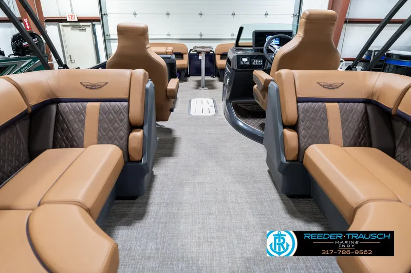 Slide: The Image of 2025 Bennington 24 MSB interior with luxurious tan seating and modern dashboard. - 19