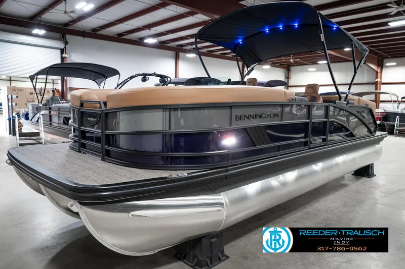 Slide: The Image of 2025 Bennington 24 MSB pontoon boat in showroom with canopy and seating. - 3