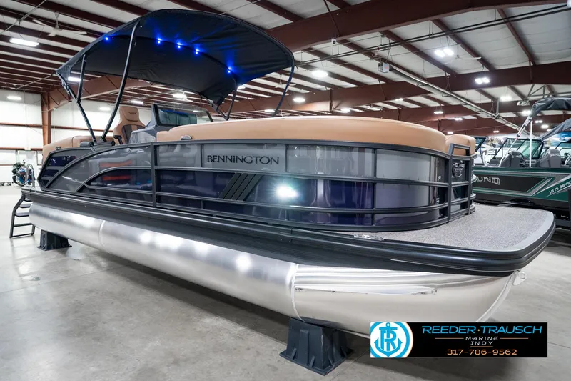 Slide: The Image of 2025 Bennington 24 MSB pontoon boat displayed indoors with canopy and sleek design. - 6