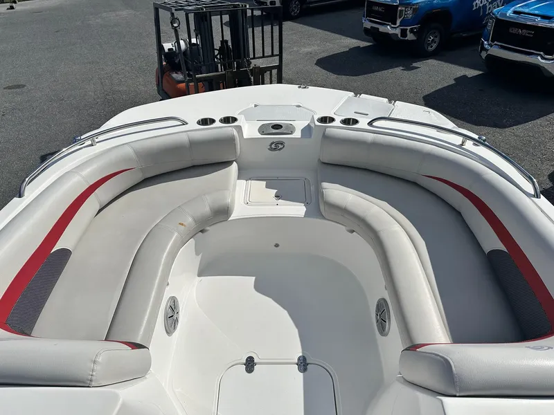 Slide: The Image of 2018 Godfrey Hurricane 188SD boat interior with white and red seating, parked outdoors. - 12