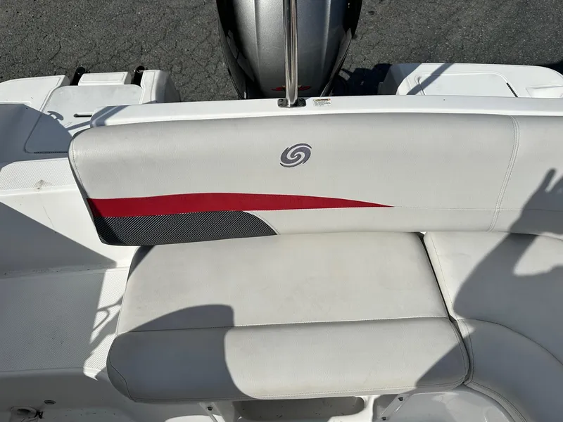 Slide: The Image of 2018 Godfrey Hurricane 188SD boat seat with red and black accents, outdoor setting. - 17