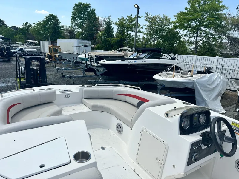 Slide: The Image of 2018 Godfrey Hurricane 188SD boat with seating, parked in a marina with other boats. - 3
