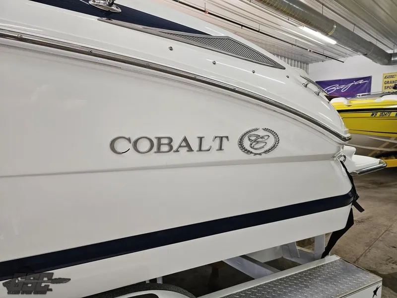 Slide: The Image of 2009 Cobalt 232 boat in showroom, side view with logo visible. - 13