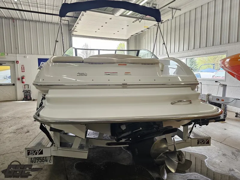 Slide: The Image of 2009 Cobalt 232 boat in a garage, rear view showing propeller and swim platform. - 18