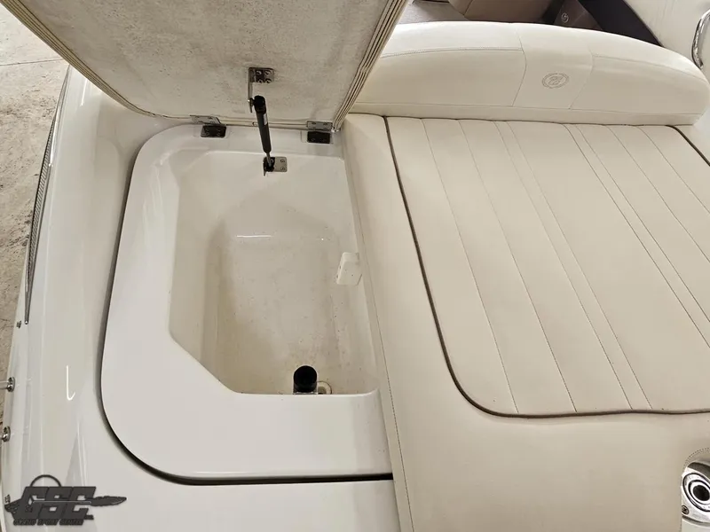 Slide: The Image of Open storage compartment on a 2009 Cobalt 232 boat with beige seating. - 24