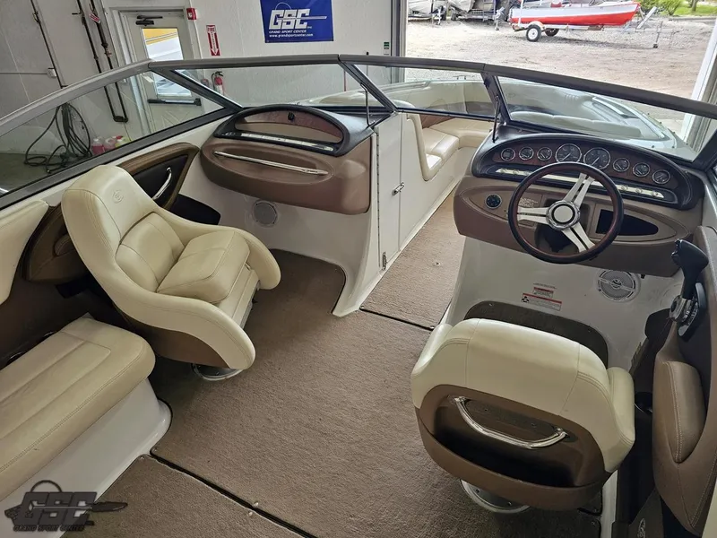 Slide: The Image of 2009 Cobalt 232 boat interior with beige seating and steering wheel, showcasing luxury design. - 28