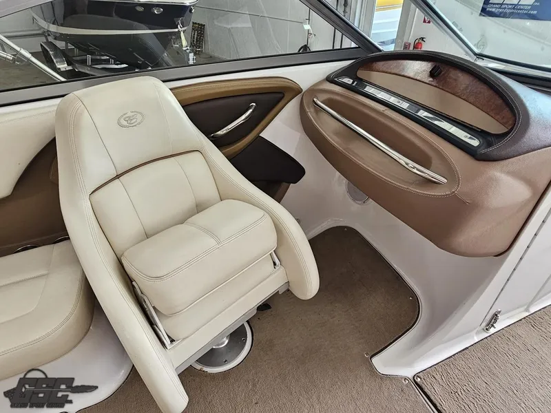 Slide: The Image of Interior of a 2009 Cobalt 232 boat featuring beige leather seating and sleek dashboard design. - 36