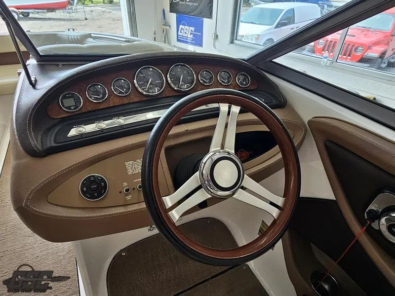 Slide: The Image of 2009 Cobalt 232 boat dashboard with wood-trimmed steering wheel and instrument panel. - 40