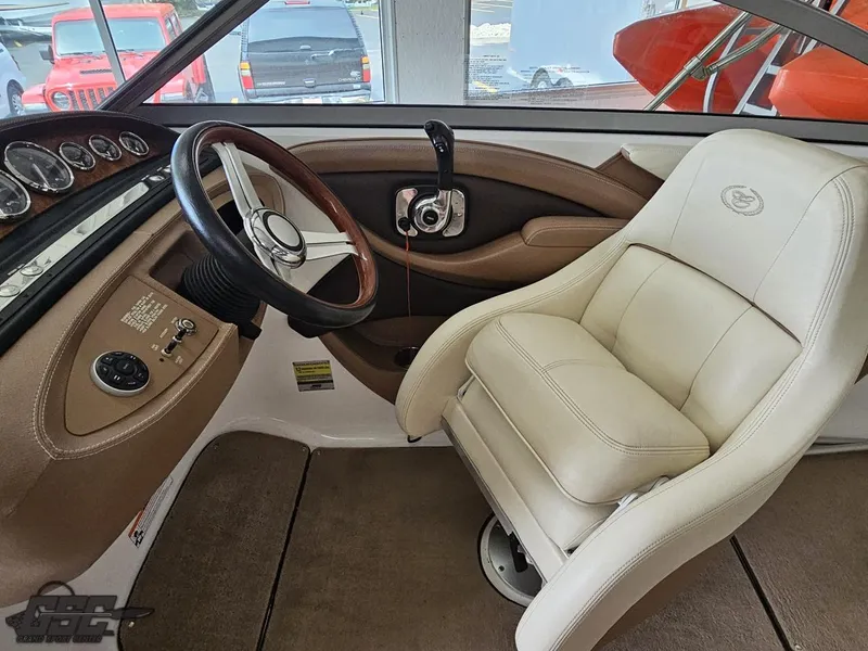 Slide: The Image of 2009 Cobalt 232 boat interior with steering wheel and beige captain's chair. - 41