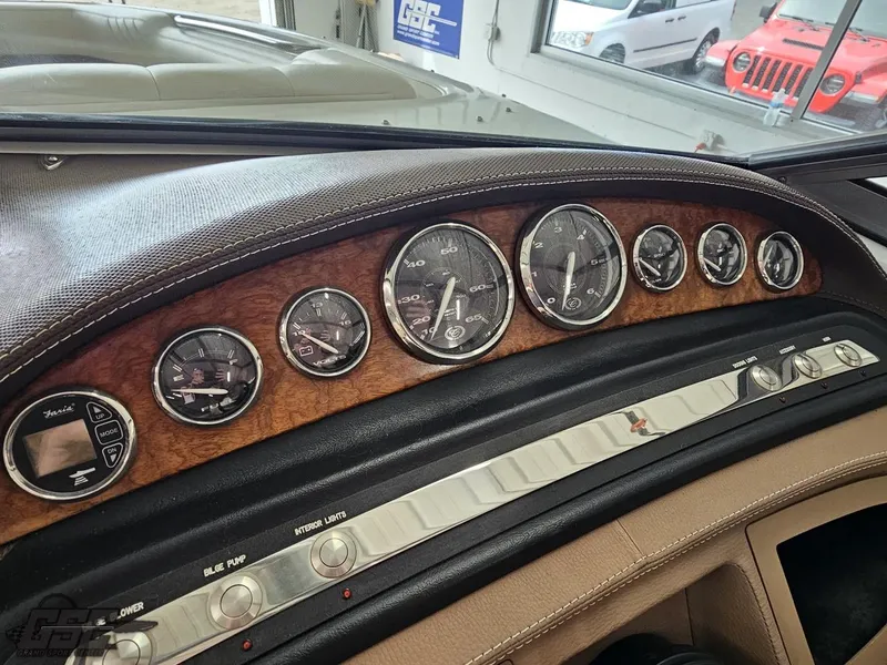 Slide: The Image of Dashboard of a 2009 Cobalt 232 boat with wood finish and analog gauges. - 44
