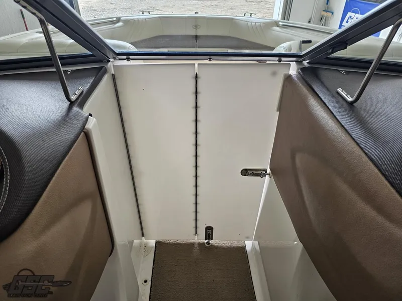 Slide: The Image of 2009 Cobalt 232 boat interior, featuring brown and white seating with a central compartment. - 47