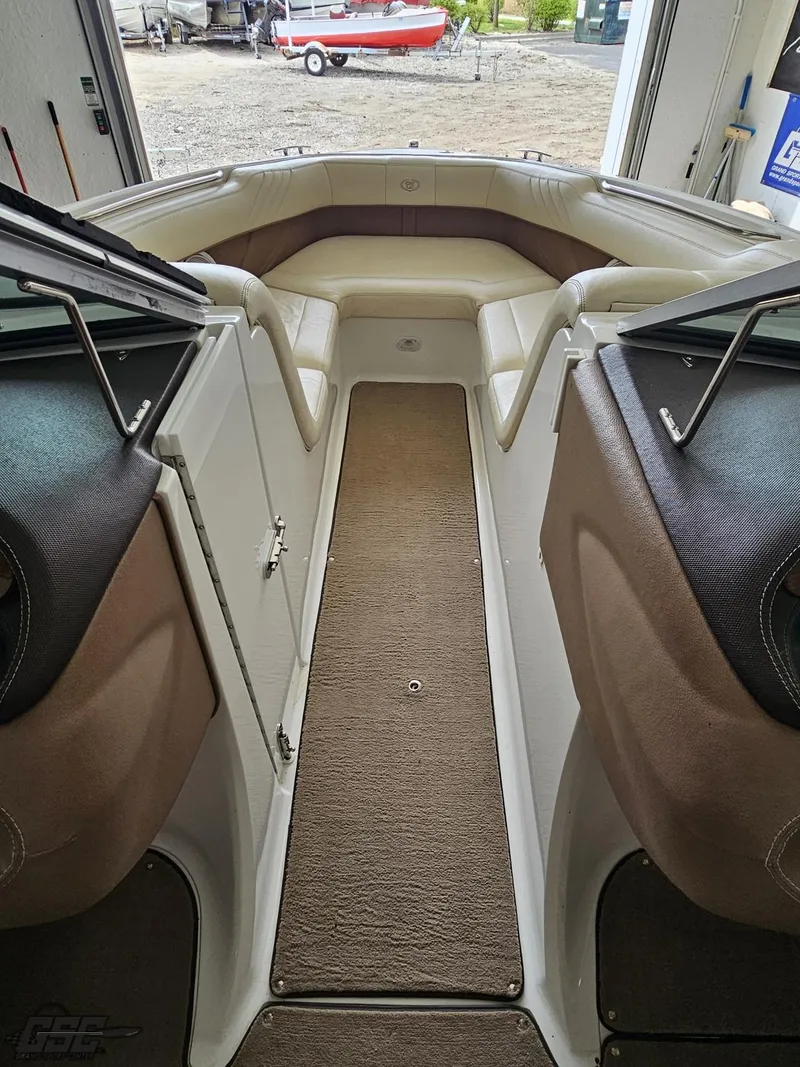 Slide: The Image of 2009 Cobalt 232 boat interior with beige seating and carpeted floor. - 48
