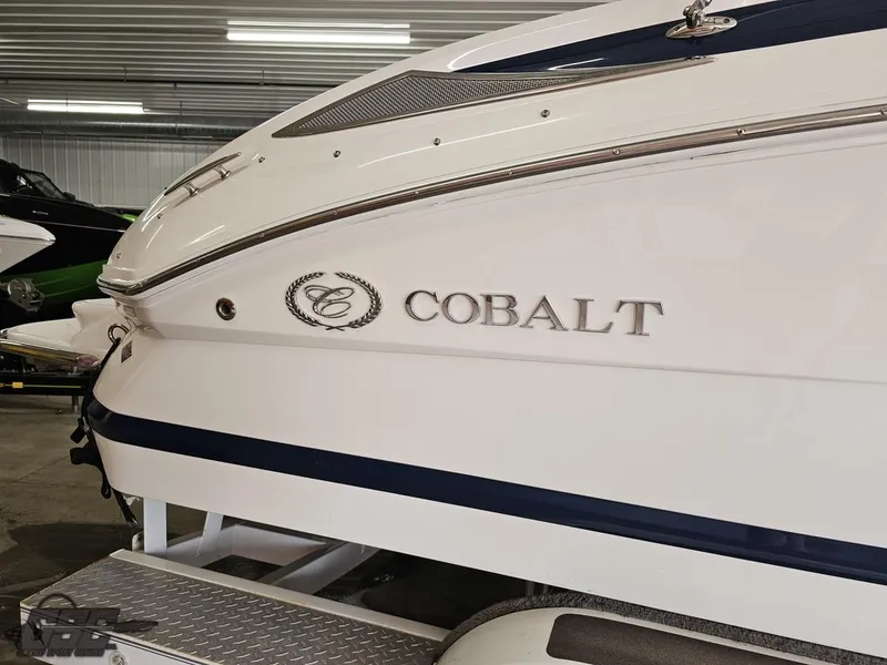 Slide: The Image of 2009 Cobalt 232 boat in showroom, featuring sleek white and blue design. - 5