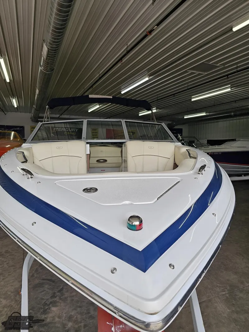 Slide: The Image of 2009 Cobalt 232 boat in storage, featuring sleek design and white-blue color scheme. - 8