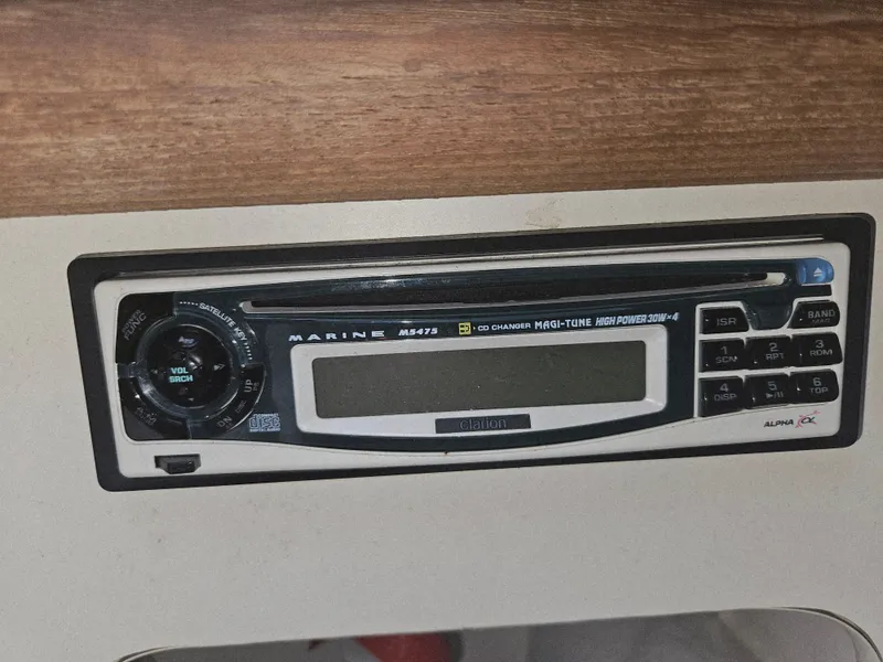 Slide: The Image of 1999 Pursuit 2460 Denali marine stereo system with digital display and control buttons. - 10