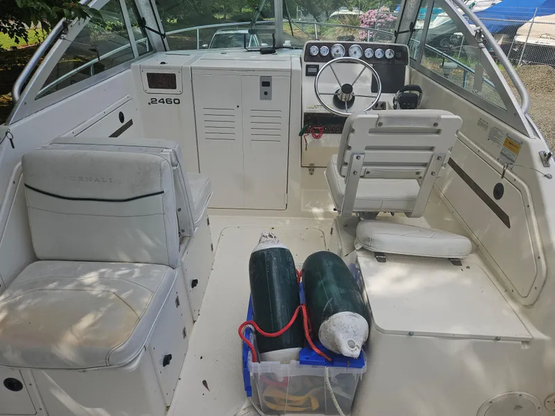 Slide: The Image of 1999 Pursuit 2460 Denali boat interior with seating, steering wheel, and storage area. - 4