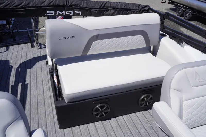 Slide: The Image of 2025 Lowe SS 210 DL boat interior with white cushioned seating and speaker system. - 13