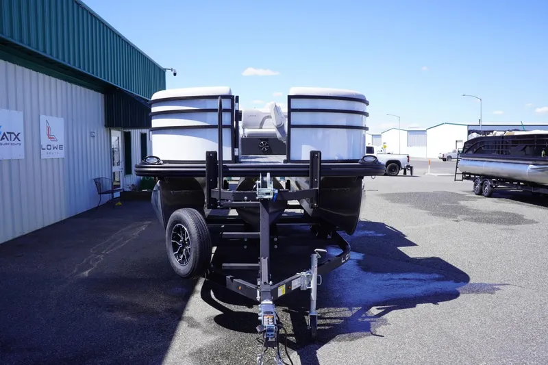 Slide: The Image of 2025 Lowe SS 210 DL pontoon boat on trailer, parked outside dealership. - 3