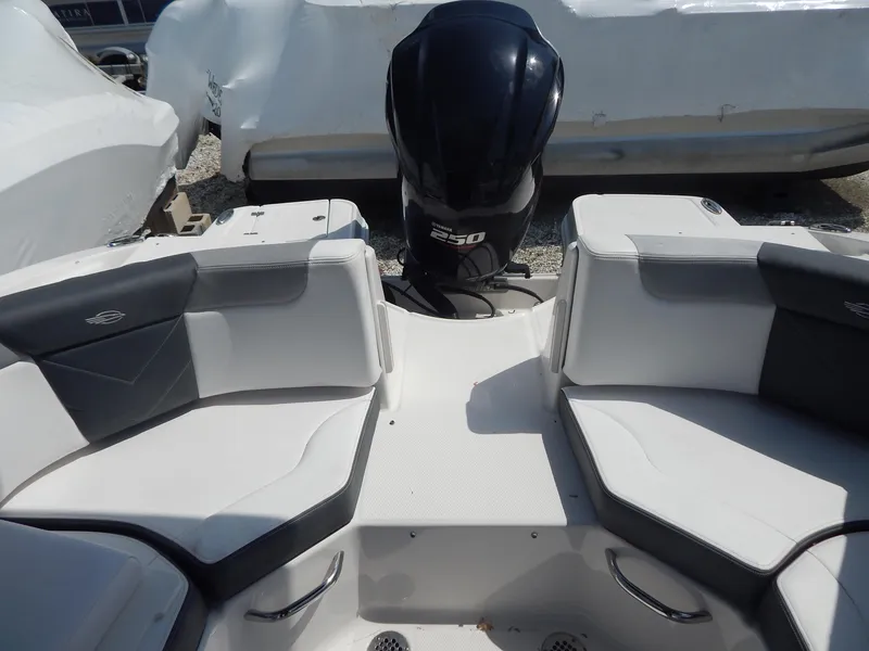 Slide: The Image of 2019 Chaparral 230 Suncoast boat interior with seating and outboard motor. - 15