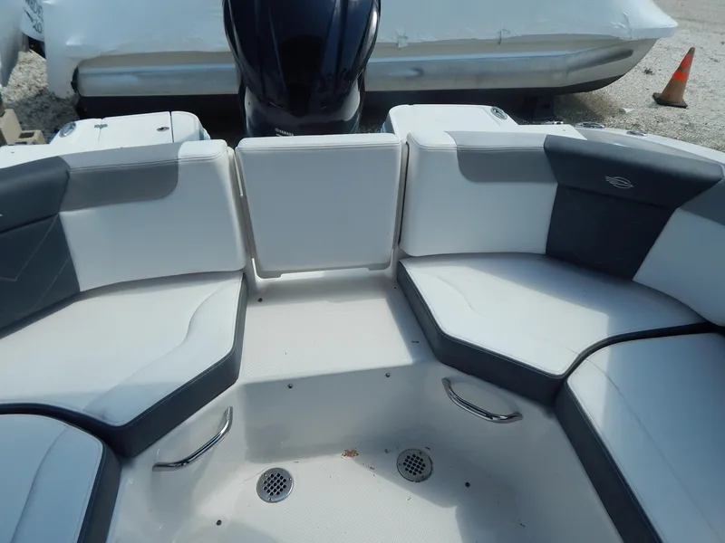 Slide: The Image of 2019 Chaparral 230 Suncoast boat interior with cushioned seating and drain holes. - 16