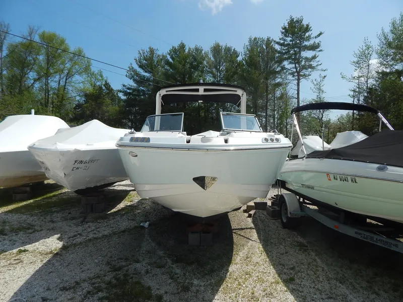 Slide: The Image of 2019 Chaparral 230 Suncoast boat on display, surrounded by trees and other boats. - 2