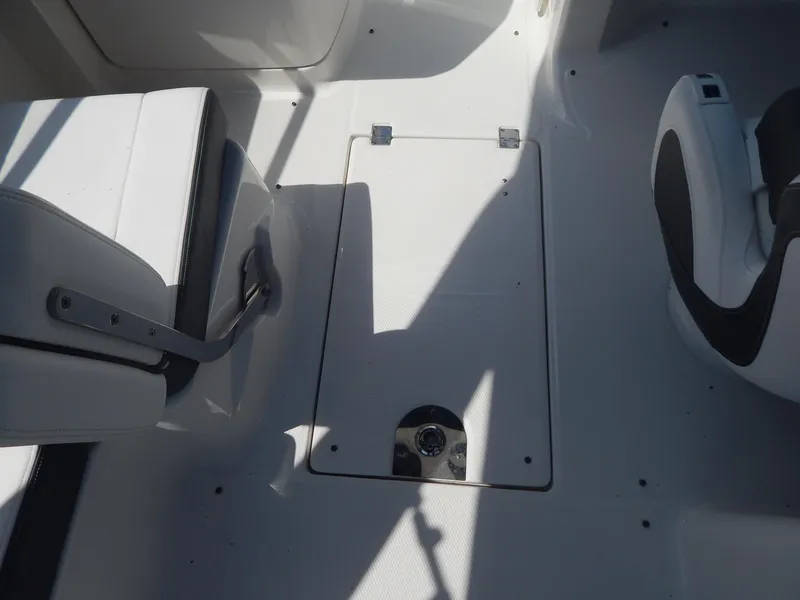 Slide: The Image of Interior view of 2019 Chaparral 230 Suncoast boat, featuring seating and storage compartment. - 24