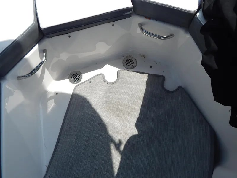 Slide: The Image of 2019 Chaparral 230 Suncoast boat interior with gray carpet and metal handles. - 27