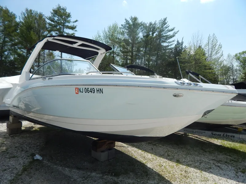 Slide: The Image of 2019 Chaparral 230 Suncoast boat on display, parked on blocks, surrounded by trees. - 3