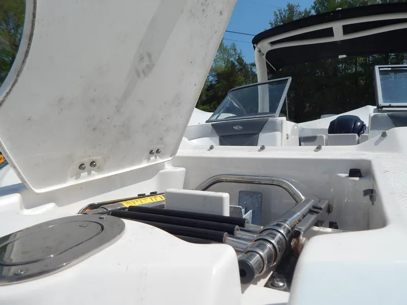 Slide: The Image of 2019 Chaparral 230 Suncoast boat interior, open storage compartment, and windshield view. - 42