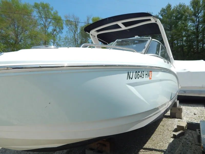 Slide: The Image of 2019 Chaparral 230 Suncoast boat on display, white hull, outdoor setting. - 44