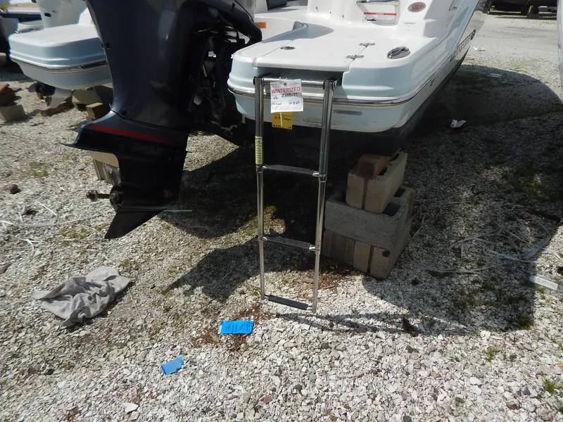Slide: The Image of 2019 Chaparral 230 Suncoast boat with ladder and outboard motor on gravel. - 5