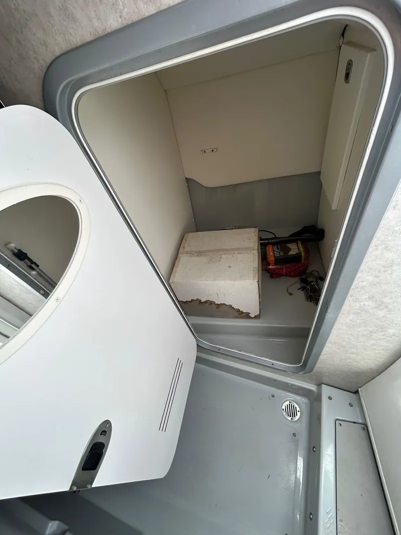 Slide: The Image of 2006 Baja Outlaw boat interior storage compartment with open door and visible items. - 12