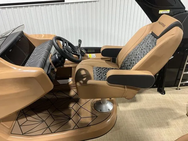 Slide: The Image of 2025 Harris GRAND MARINER 250 SLDH boat interior with tan captain's chair and steering console. - 16