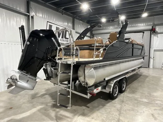 Slide: The Image of 2025 Harris GRAND MARINER 250 SLDH pontoon boat in showroom, featuring Mercury outboard engine. - 7