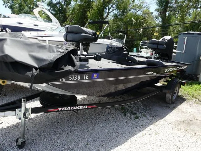 Slide: The Image of 2022 Tracker Pro 170 boat on trailer, parked outdoors, surrounded by trees and other boats. - 4