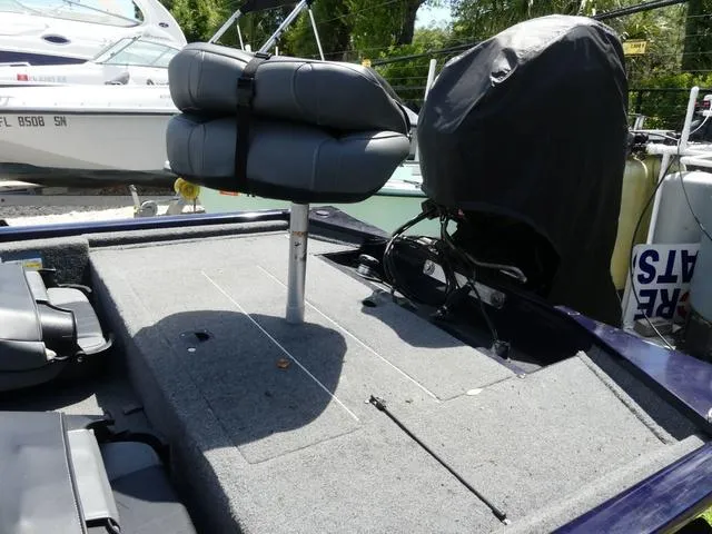 Slide: The Image of 2022 Tracker Pro 170 boat with cushioned seating and motor, docked outdoors. - 6