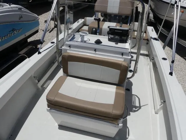 Slide: The Image of 2019 Parker 1801 CC boat interior with seating and console, in a marina setting. - 12