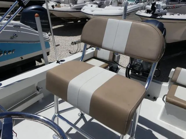 Slide: The Image of 2019 Parker 1801 CC boat seat with beige and white upholstery, in a marina setting. - 9
