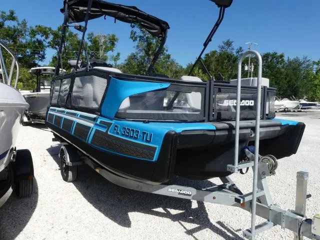 Slide: The Image of 2023 Sea-Doo Switch® 16-130 hp pontoon boat on trailer, parked outdoors. - 3